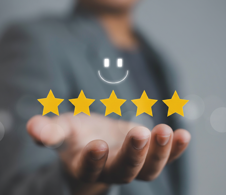 Smiling face above five yellow stars on hand.