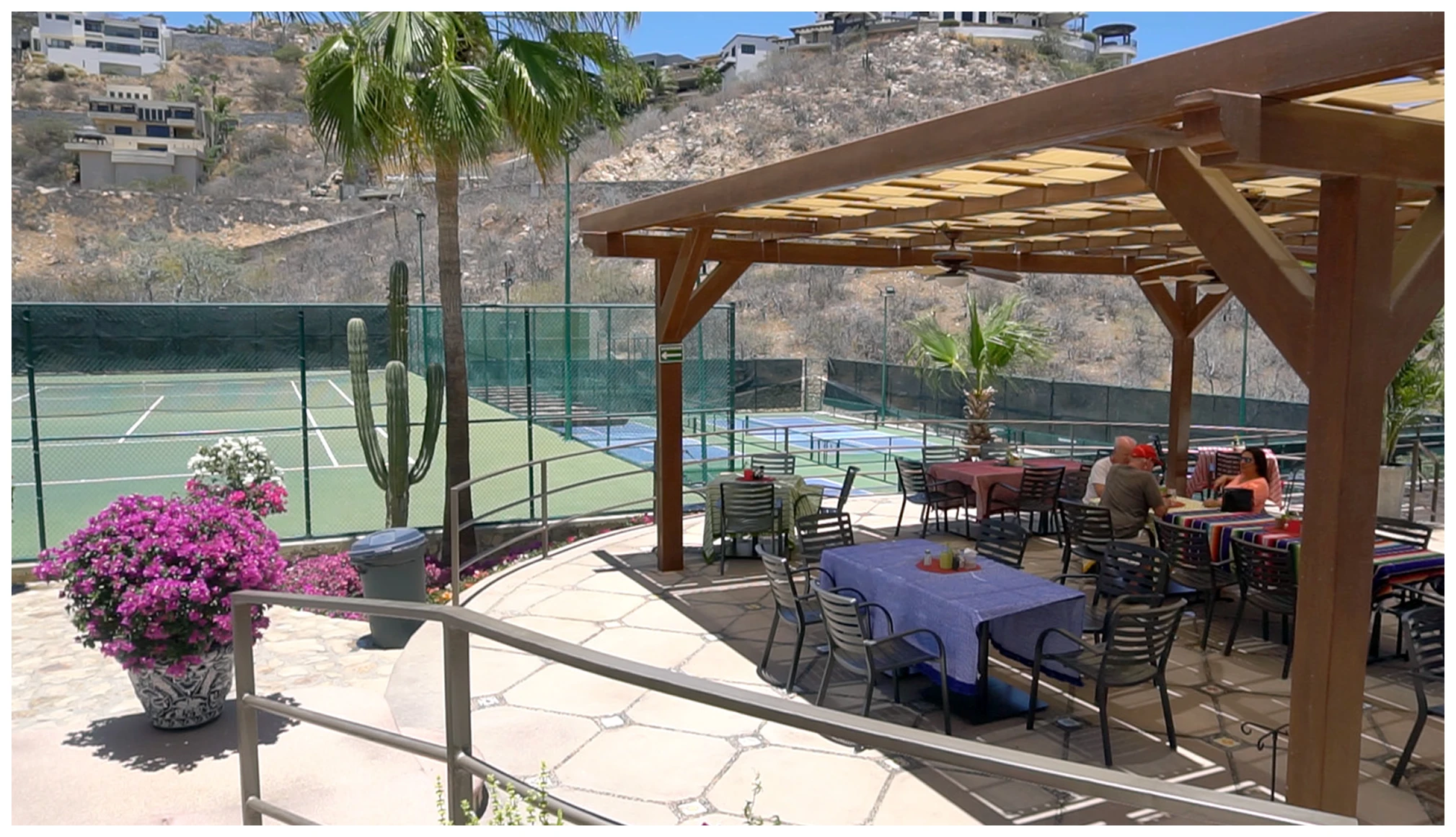 Outdoor dining area next to tennis courts.